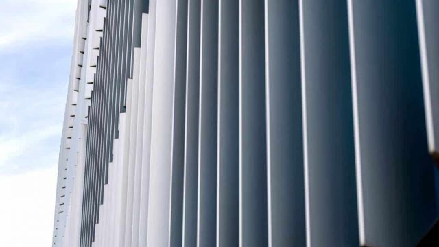 The facade of a modern building with an innovative facade made of automatic, movable blinds.